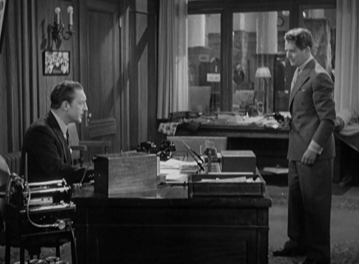 Warren William spends most of the movie behind his desk, a place of power and intimidation. 